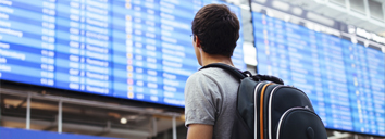 A student at an airport, ready to travel, work and study abroad with C1 Advanced English